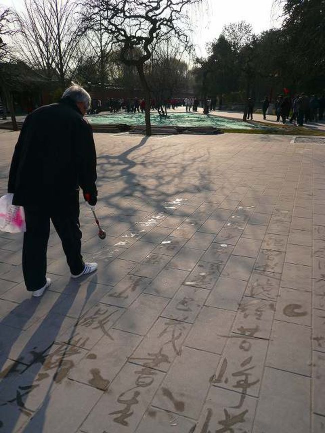 水で字を地面に書いてました。天壇公園や北海公園ああたりの広場でも同じことをしているおじ様を見かけました。中国らしい風景ですねえ。