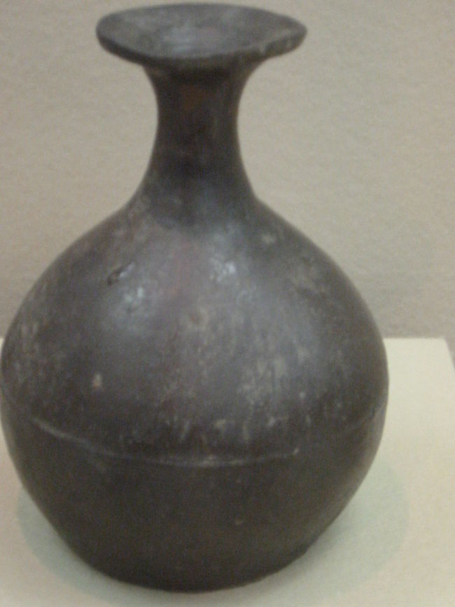 褐釉線条文瓶<br />朝鮮・・１６世紀〜１７世紀<br /><br />叩き成形で作られた瓶<br />壷や甕にかけられるたぐいの褐色の土灰釉が掛けられている<br />唐津焼の瓶のもととなった朝鮮半島の瓶であり、貴重な資料である<br />胴部に堆線がめぐらされている<br />