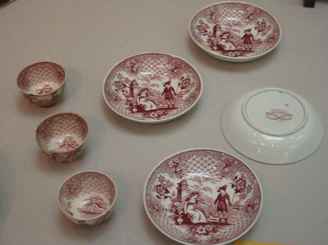 ・紅彩人物犬文小杯〔銅版転写〕<br />・紅彩人物犬文小皿〔銅版転写〕<br />オランダ・マーストリヒト　ベトゥルス・レグゥート窯<br />１９世紀後半<br /><br />西洋の人物の衣装や風景、そして銅版転写の細かな線で陰影をつける<br />三次元的な絵文様は、日本の西洋への関心を喚起させたことだろう<br />高台内にベトゥルス・レグゥート窯の王冠に紐のマークと意匠銘の<br />PRETTY  LONDONの文字が入れられている<br />