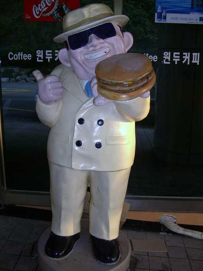 17:00　怪しげな人形<br /><br /><br />海を見ながら、ゆっくりとタヌビ列車はおよそ10分程度で展望台に到着です。<br /><br />写真は展望台でバスを降りたところにいた怪しげな人形です。<br /><br />ハンバーガーを持っているので、ハンバーガー屋さんの人形なんでしょうか？<br /><br />展望台の中にはそれらしいき店がありましたが、詳細は不明です＾＾；