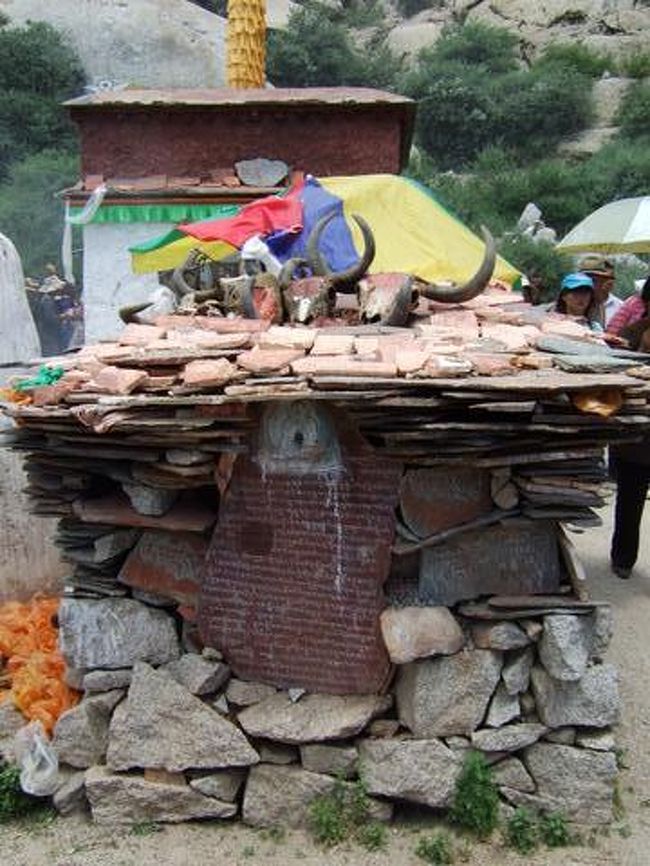 マニ石<br />専門の彫り師が彫った供養物。<br />彫り師の個性でマニ石のデザインも色々。<br />観音菩薩に讃える念仏「オムマニペメフム」・経文・神仏の絵など有ります。<br /><br />私は小さいのを買ってきて<br />自宅で文鎮代わりに使っています。 