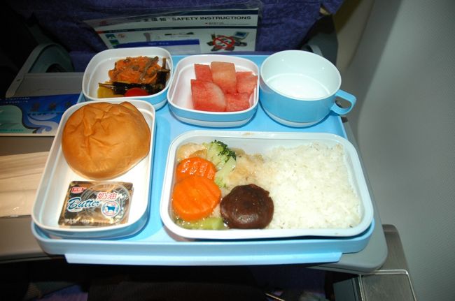 帰りの飛行機は上海の主力空港「浦東空港」からエアチャイナ（CA）で成田まで。<br />なぜ帰りが浦東かというと、行きに使った羽田〜上海（虹橋空港）は、上海の最終便が13時発なんですよ。これでは上海市内に11時までしかいることができません。<br />浦東便だと最終は17時台です。そこで行きと同じ航空会社じゃつまらないのでCAにしてみましたが、乗ってから後悔しました・・・(-_-;)。<br />だって、機内食はご覧のような魚料理がラップにくるまれて出てきますが、ほとんど味がしませんでした。付け合わせの漬物のような野菜はゼッタイに人口着色だなとわかるくらい鮮やかな色ですが、味がしないんです。