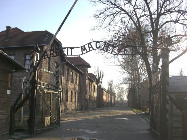 アウシュビッツに到着です。クラクフから１時間半くらい。どこで降りるのか分からなかったのですが、隣の席の人が教えてくれました。<br />有名な「ARBEIT MACHT FREI（働けば自由になる）」の門です。私はアウシュビッツを見たらきっと涙が出てくると思ったのですが、この門の前に立ったとき、不思議なことに涙は出ませんでした。ただ「ここまで来たんだ…」というだけ。そう、リアリティがないのです、この場所には。<br />朝早かったせいか、私たち以外に観光客はまだ誰もいませんでした。