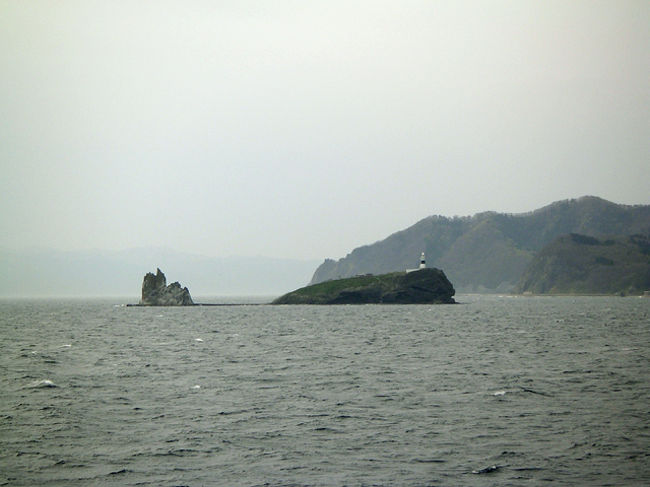 だんだん下北半島が近づいてきた。<br />鯨みたいな形をした島には小さな灯台が。