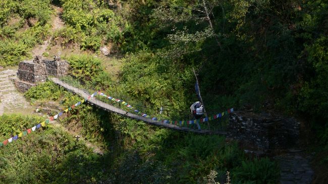 タルチョがはためくつり橋。<br />この日のトレイルは川を渡るためにアップダウンが何度か続いた。<br />また、この日は標高1650mのダンプスから2100mのデオラリへ行き、400mほど標高を稼いだが、泊まったランドルンは1640mであった。<br />