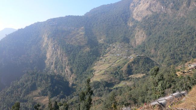 Sinuwa（シヌワ・2360m）への途中の登りにある<br />ゲストハウス（Hotel Himal)で小休止し、チョモロン方面を望む。<br />左側の山の上に見える集落が泊まった宿の集落。<br />チョモロンからへシヌワへは急な石段の上り下りがあり、平面図では近そうだが石段の一つ一つが段差があって結構きつい。<br />夫は前日飲んだホットミルクで体調を崩したらしく、この登りの石段がかなり堪えたようだった。<br />