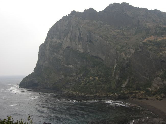 『城山日出峰』で入場料を払い、側まで行ったのですが、あまりに風が強く、寒くて寒くてとても上まで登る気にはなれませんでした。先程のちょうど反対側からの写真です。海底火山が噴出して出来た凝灰丘で、頂上から眺める日の出は非常に美しいとのことです。<br />