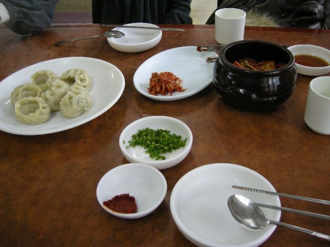 『マンドゥ』（餃子）1つと『カルククス』2つ注文。<br />壺いっぱいのｷﾑﾁがやってきました。それから、雑穀米のような、ご飯が2人に1つ。<br />ﾏﾝﾄﾞｩうま〜ぃ。皮が厚めでﾓﾁﾓﾁ♪