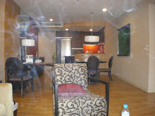 タバコの煙が漂っていますが、正面がキッチン食事用の丸テーブル手前がリビングです、広々としてます。<br />右の壁の奥はツインの寝室、左奥が入り口。