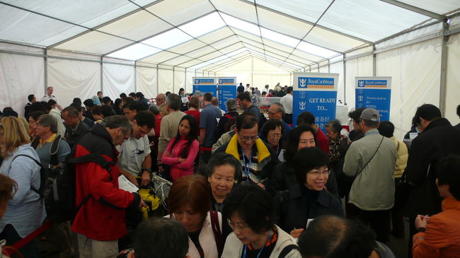 乗船ターミナルの仮設テント内です。<br />冷暖房の設備は当然有りません。<br />受付所は１５箇所位有ったと思います。<br />受付の係員が、乗船チケットに記入しているのに、緊急連絡先やクレジット番号を、責任者に尋ねに行く始末。<br />おまけに、パスポートに氏名や部屋番号を記入した用紙を、家内用と反対に貼り付けているのを、乗船後気づいた。<br />この状態では、不慣れではなく不勉強ですね。