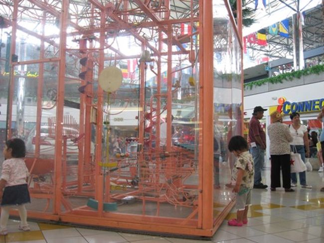 13:30　ホテル到着。<br />シャワーを浴びてから赤いトロリーに乗ってマイクロネシアモールへ。<br /><br />＜マイクロネイアモール＞<br />フードコートで軽く食べてから行動開始。<br />メイシーズではONEDAY SALE開催。<br />子供服が50％OFFになるなど、お買い得品満載。<br />買わなかったけど。<br /><br />←早速なんちゃってピタゴラ装置に釘付けの王子。<br /><br />ペイレススーパーマケットでおみやチェック。<br />いつ来ても寒いぞ、ここは。<br />ジップロックとお菓子を買って早々と退散。<br />帰り際、ウィンチェルズでドーナツ購入。<br /><br />帰りのバスでは家族そろってで爆睡かっとびました。