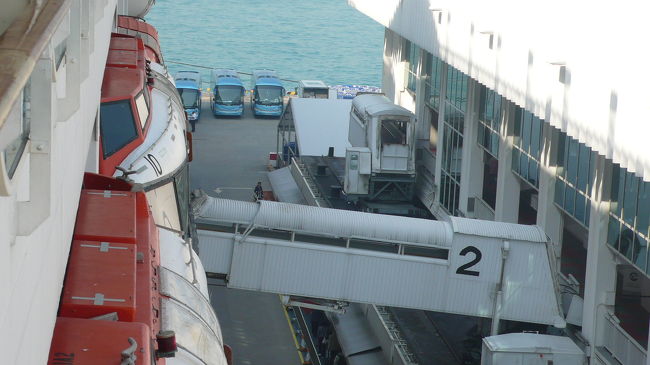 この連絡通路を渡って上陸します。<br />奥には出迎えの観光バスが数台並んでいます。