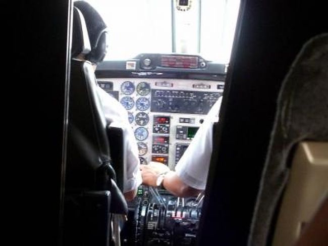 飛行機の中。自由席。<br />前方のパイロット席も丸見え。開放的