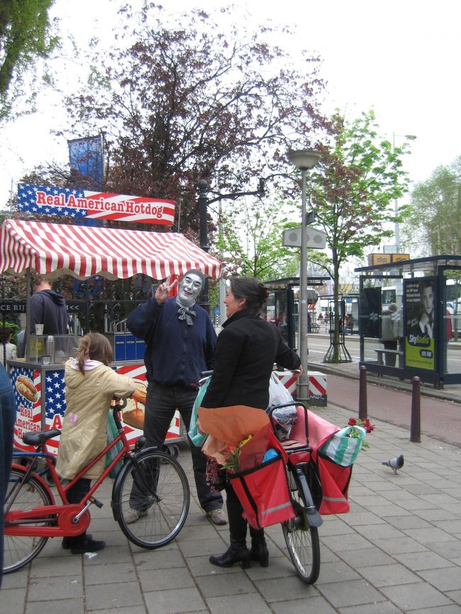 国立博物館前での一コマ。毎日お買い物に出かけるお母さんのママチャリには結構な容量のカゴが装備。買い物カゴから花が覗いているのはオランダらしいかと。<br />