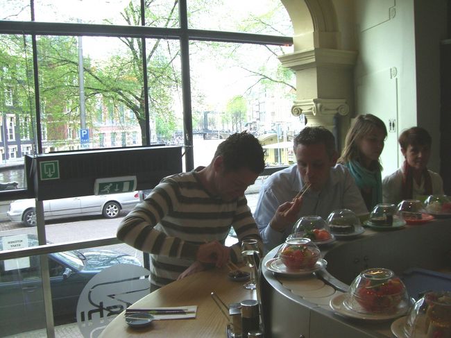 驚きました。３０席ほどのお店ですが、周りを見回しても日本人と思しきは私たち夫婦だけで、お客さんの全てが外国？人。私たちが陣取った隣の先客は、「おぉ、日本人だな、ホレ見ろ、俺たちだってこうやって寿司をカッコよく決めてるんだぜ！」とばかりに得意気な笑顔を私に投げかけてくれました。<br /><br />お箸の使い方など皆さんとてもお上手でビックリ。変則的な私なんぞは、いやはや、恥ずかしい限り。私たちが注文するネタとか食べ方が横目で視られているような気がして、少々緊張。回転寿司屋さんでこんなに襟を正して？食べたのは始めてのことでした。<br /><br />バナナロールだとか一風変わったネタもありますし、また、凝った巻物が多くて一見ではそれが何なのかが分かりづらいという難点もあります。でも、それはそれで「寿司」がご当地の食べ物として消化され、根付いていってるということでしょう。寿司好きには本当に嬉しい世界への普及ぶりです。<br />