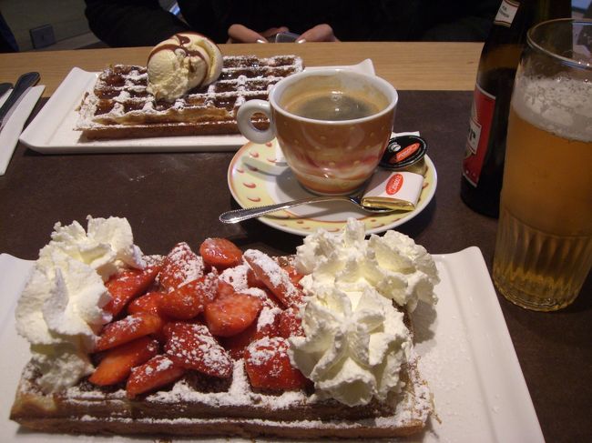 依然として雨も上がらず。近くのワッフル屋を覗くことに。<br /><br />「あぁ、今、満席だなぁ、ゴメンよ・・・いや、待てよ、アンタらついてるネ、今、空いたみたいだからあそこへどうぞぉ！」と気の良さそうなオヤジに中へ案内されました。ワッフルの本場はブリュッセルとは知りつつも、「別に何処でも良かろう」と行き当たりばったり、雨のせいで成り行きで入った店。でも、これがビンゴでした。<br /><br />ご覧のように見た目には怖気づいてしまいますが、これが意外や意外、甘さ控えめであっさりとした美味しさ。ワッフルも表面サク、中はしっとり、の絶妙の食感。隣では９０歳も近いだろうにと思わせる老夫婦が私たちと同じものを食べておられましたが、心配をよそに当然の如くにペロッと平らげておられました。私もそのおばあさんを見習って、飲み物はベルギービールといってみました。<br /><br />ちなみに、ツアー仲間の多くは教科書通りにブリュッセルの老舗で食べたそうですが、甘すぎてドーンと来るハズレだったそうな。その点、私たちはラッキーでした。<br /><br />俄然ワッフルに目覚めた家内は帰国後早速にワッフル焼き機を楽天に手配。いやはや行動が早い。そして昨日それが届きました。我が家の食卓にもしばらくは顔を出してくれるのかも？<br />