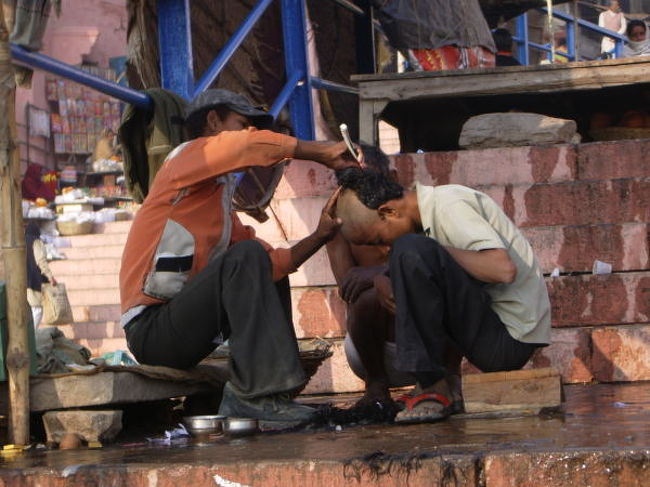 バラナシのガンジス河のガートで髪を剃る人。<br />つるつる。
