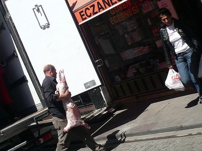 何やらトラックから運び出しているおじさん。<br />よく見てみると...<br />皮も剥いで、頭もないですが、大きさ的に羊かな。