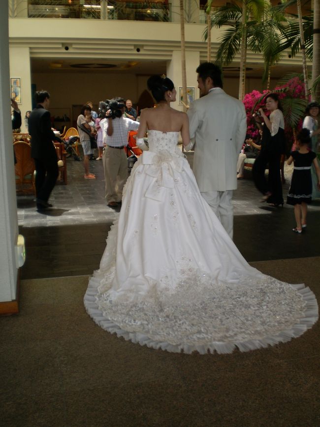 オープンカーを降りた新郎新婦は、これから<br />披露宴です。<br /><br />なにしろたくさんの食べ物が出たそうです。<br /><br />それにしても、花嫁のドレスの長い裾がなんとも<br />印象的ですねぇ…<br />