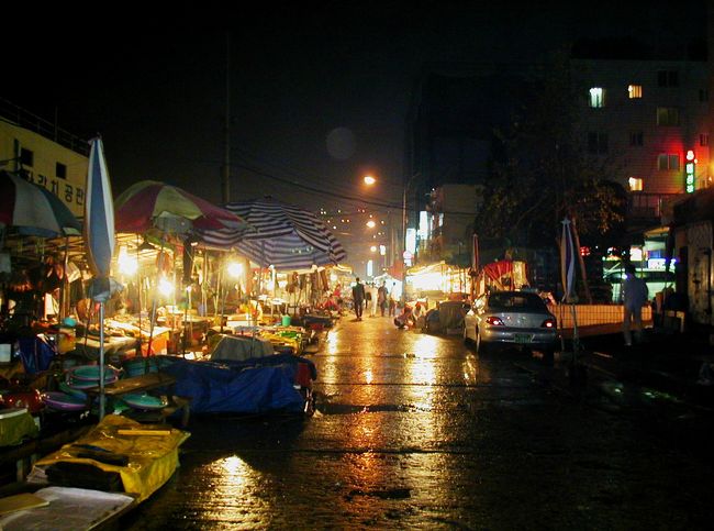 今の時間は雨が上がっていましたが、濡れた通路が夜の明かりを反射していました。右手奥は直ぐに海になっています。
