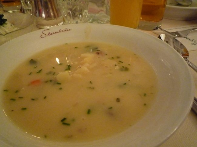 では、本日のディナーです。<br /><br />おいおい、さっきケーキ食べてたでしょ！と突っ込んだそこの(・_・)σアナタ<br /><br />甘いです！<br /><br />この間に数時間たっているのです。<br />カフェの後、お土産を物色しに旧市街地をウロウロしておりまして、<br />でも、お店も閉まる時間になり、あまり買うものがなく・・・。<br />しょうがないので、モーツァルトの生家の前で1時間ほど休憩してました・・・。<br /><br />と、話を戻しまして<br />本日のディナーはサウンド・オブ・ザルツブルクというディナーつきショーへ、<br />我が家とOさん夫妻とご一緒に参加してきました。<br /><br />場所はステルンブロウというレストランの中です。<br /><br />受付に並んでいたのですが、なんだか受付のおばちゃんが手際が悪く、<br />あまり並んでいないのに結構待たされました…。<br /><br />さてさて、席に着いたらまずはディナーです。<br />ＢＧＭにはピアノの演奏です。<br /><br />まずはスープ<br /><br /><br />