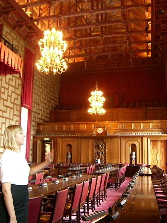 「市議会の議場」と私たちのガイドのお姉さん。<br /><br />今でも実際に使われている議場です。<br />船をひっく返した、<br />天井＝船底の面白いデザインです。<br />ヴァイキングルネッサンス様式だそうです。