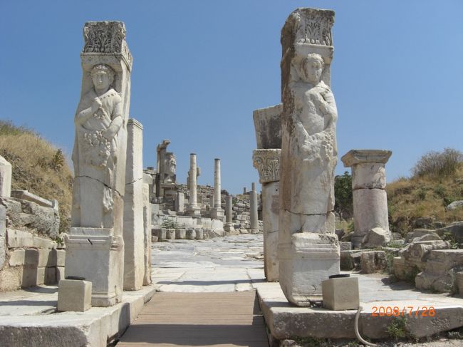 さて、本日のメイン！エフェソスだ！エフェスとも言うけど。どっちがホント？<br />ガイドさんの後に続き、色々説明を受けながら、直射日光と戦いながら、遺跡の中を進む。夏の観光シーズン。色んな国からの観光客で、ごった返している。<br />そこーで、私は気づきました。「日傘を差すのは、日本女性だけである！」<br />欧米人は、帽子だけ。帽子もかぶらない人もいる。韓国人あるいは中国人は、傘を差しているけれど、ふつーの折り畳み。黒い日傘は、日本人の証拠ww。<br />日傘だけでなく、日よけの手袋、長袖・・・。日本人は、UVカットに必死だぁー！ww