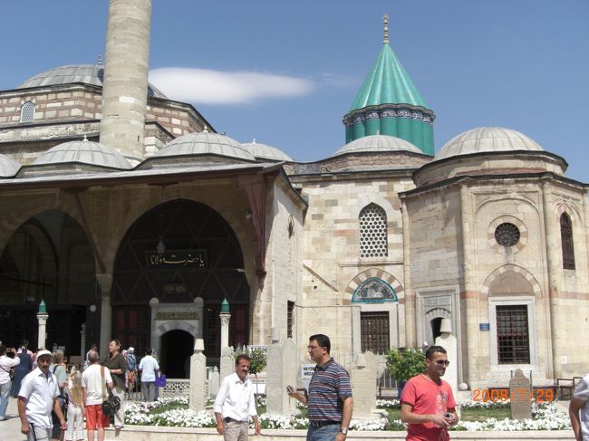 さて、昼食は、トルコ風ピザ。これは、なかなかいける。デザートもおいしかった。「これって、ういろうみたいだねぇ」後で調べると、ミルクを煮て作った「カザンディビ」というものだった。<br />それから、パスはコンヤを目指す。<br />そこで、イスラム神秘主義の「メヴラーナ博物館」を見学。メヴラーナさんはイスラム教徒であるにもかかわらず、「あなたが、キリスト教徒でも、どんな人間でも私のところに来なさい」と言ってくれた、心の広――いお方である。ああ、その一言だけで救われる気がするよ。メヴラナさん、(・∀・)ﾓｴｯ♪。<br />博物館はたくさんの人で、ごった返している。いまだ多くの信者がいるということなのだろう。男性は普通に半そでシャツにズボン姿。しかし女性は、頭にスカーフの他、何故かくるぶしまでのロングスカート。大人になると、その上からロングコートまで着ている。暑いだろうなぁ・・・。