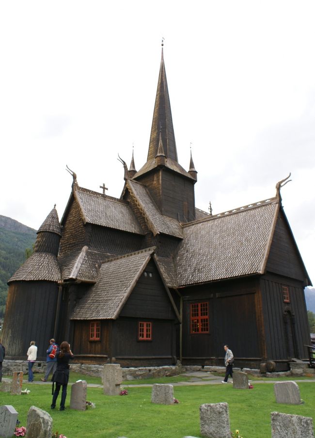 後ろから見た教会<br /><br />後ろ側は防腐剤として塗られたコールタールの色が残って、別の建物みたいに黒々としている。<br /><br />緑の芝生に映えて、とても美しい。<br /><br />土葬ではないそうですが、お墓が並んでいるので、歩くのに神経を使いました。<br />