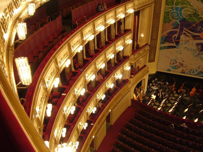 興奮のあまりどこをどう撮ってよいかわからず、とりあえず上まで行って、そこから撮ったバルコニー席。<br /><br />私はこのバルコニー席でした。<br />４人用の個室となっていて、その中でも後ろの席だったので<br />全然舞台が見えず、歌だけしか聞こえませんでした。<br /><br />昔は今のように、皆が舞台を見やすいような客席の設計になってはおらず、伝統あるこの国立オペラ座も<br />もちろん昔の客席のままとなっているので、見えないのも仕方ないとの事だった。<br /><br />ちなみに私たちツアーは、一番安い席で皆バラバラの<br />席だったので、個室の他３人は外人だった。