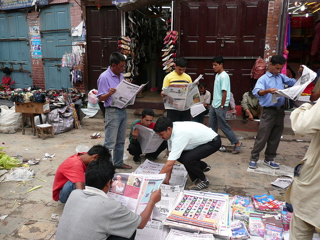 カトマンドゥ　タヒティ・チョークの朝市<br /><br />道端の新聞売りの新聞をしっかり立ち読みするカトマンドゥのおやじたち<br />