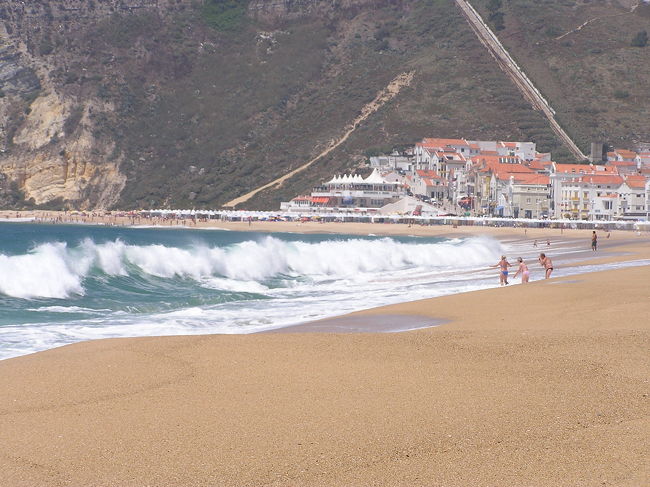 ナザレの街の海。<br />一応ビーチで泳いでいる人はいるものの、波が高い。<br />この高さは日本では確実に遊泳禁止だろうと思われるものの、大西洋に面した田舎街では自由に泳げちゃう感じでした。リゾートではないものの砂浜も海もリゾートとは違った自然なきれいさでした。