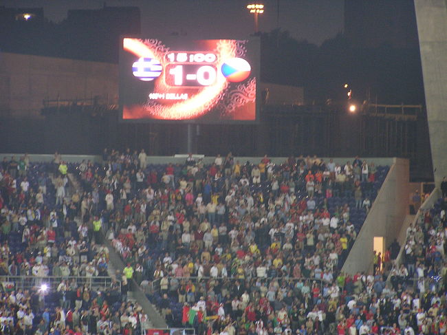 いざ、試合が始まると対面のギリシアサポーター達の団結した地響きのような声、すさまじいものでした。その点、人数も圧倒的に少ないチェコ側はおとなしく観戦といった感じ。<br /><br />試合は前後半おわって０−０、攻めるチェコ、守るギリシアといった展開。<br />０−０で延長前後半も終わりそうな展開で、残りわずか。目の前でギリシアのコーナーキック。あと少しでＰＫというところで、目の前のＣＫからギリシアのゴール。あと数分、悲劇的なゴールでギリシアの勝利。チェコファンとしては周りのサポーターと同様呆然でした。