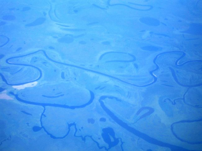 まさにオリンピックで連日熱く盛り上がっている北京の上空をほどなく通過。<br /><br />そして映画も一、ニ本は楽しんで退屈になってきた頃合、窓から下界を覗くとそこには夏のシベリアが。快晴のシベリアを上空から眺めるのは、私にとっておそらく初めての経験。<br /><br />激しく蛇行して大地に描かれる大河の曲線は、法則があるようで無いようで、クレーの絵画を観ているかのような神秘的な意匠。土木も治水も及ばない大自然のなすがままあるがままの世界を、遥か上空からしばし楽しむことが出来ました。<br />