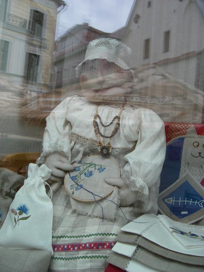 ショウウィンドウ越しの刺繍おばさん人形。<br />おばさんが刺繍しているのが、<br />エストニアの花。<br />