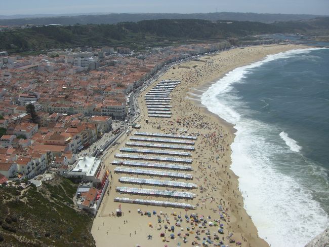 ナザレ。上の街から眺めたビーチの広がり。どうしても教会見物が中心の観光が続く中で、ナザレのリゾッチャな明るい雰囲気は気分転換に最高でした。<br />