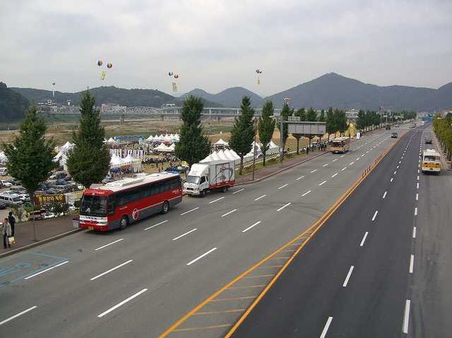 車に乗って対岸へ<br /><br /><br />祭りを見終わったので、一度戻ってきて車に乗り、対岸のレストランに向かいます。<br />錦江（クムガン／Geum-gang）沿いの道は結構広い道路です。<br /><br /><br />■Photolibrary<br />http://www.photolibrary.jp/img66/69_197148.html