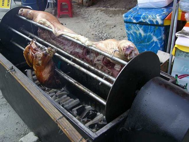 手動の焼き機<br /><br /><br />こんな感じで、回転台のようなものにくっつけられた豚を焼きます。<br />おばちゃんがゆっくり手動で回しています。<br />焼き加減を考慮してか、あくまでも手動で回すようでした。