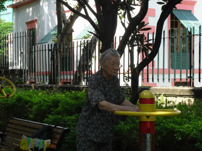 ルイス・カモンエス公園でおばあちゃんが健康器具を使って運動しています。