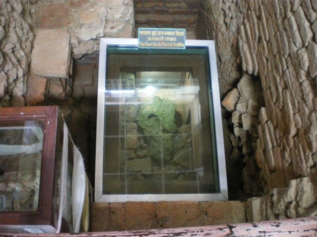 ブッダ誕生の場所を示すマークストーン。<br />"Marker Stone   The Exact Birth Place of Buddha"の説明文が添えられている。1992年から行われた大規模な発掘調査により、この石がマーヤー聖堂の真下から発見された。このことによって、この地が仏陀生誕の地である動かぬ証拠となった。 