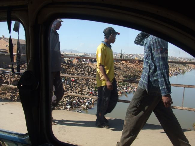 タナ郊外のホテルからタクシーでタクシーブルース乗り場へ。タクシーブルース乗り場は行き先によってわかれていて、ペリネ行きはeastern taxi-brousse stationからでした。Arが残り少なくなったので両替のため銀行へ。両替できる銀行は限られていて、１件目、２件目はＮＧ。２件目で教えてもらった銀行（BFV-Societe Generale Antaninarenina支店)で、やっと両替。円→Arのレートは、空港よりも相当よかったです。<br />ところが、通常ホテル→タクシーブルース乗り場まで40分程度のところ、銀行を探すのに40分ほど余分にかかっってしまい、タクシー代も当初予定の倍の30,000Ar（2,200円ぐらい？）でした。<br />写真はタクシーから見たタナの川。洗濯物を川原に干している。<br />