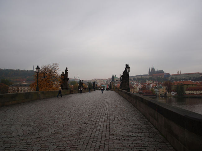 両脇の聖像彫刻の間をマラー・ストラナ側の橋塔方向へ歩きます。右側の丘の上に立つのはプラハ城です。<br />補修工事を行っていました。