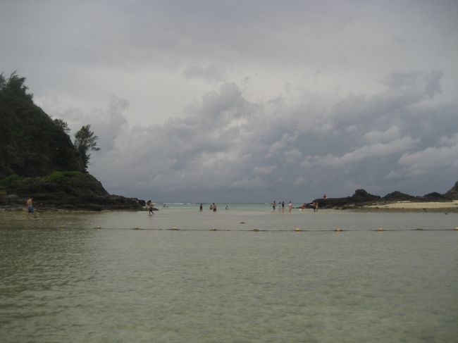 干潮時で目の前では泳げず、左側の岩場のほうにはけっこう人がいます。<br /><br />こんな天気でも、みんなビーチに来て楽しんでるんだな〜と目の当りにして、台風に嘆いてばかりの自分に反省。<br />
