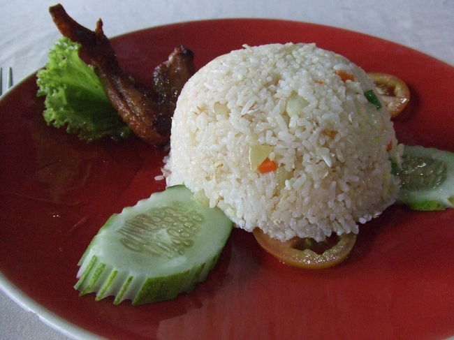 アンコールワットを見終わった直後、雨が降り出しました。<br />ものすごい勢いで降るんですよね〜。<br />雨宿りを兼ねて、近くの食堂で早めのお昼ご飯にしてもらいました。<br />チキン＆フライドライスです。<br />でっかいキュウリはこの後どこでも見かけます。