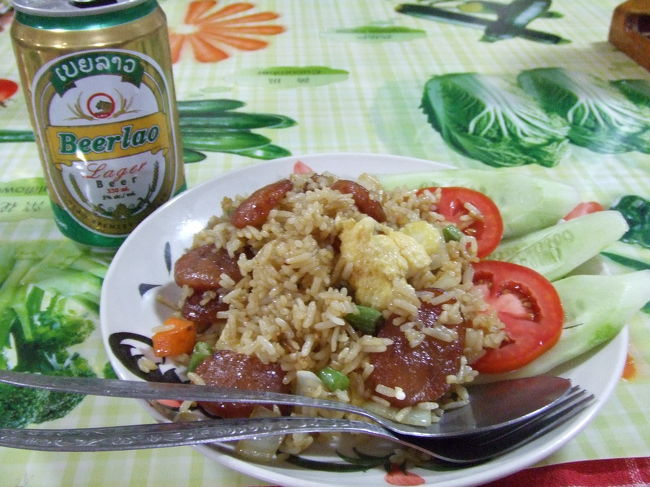 ラオス最後の夜に乾杯！ってことで、ソーセージ入りフライドライスとビアラオを注文♪キクカワ君は、ビアラオとカレー。タカハシさんは何やらわからないものを注文していたけど、運ばれて来たのは"おかゆ"でした。『あれ？思ってたのと違った。。』だって。ウケル♪<br />タカハシさんから私達に記念にと中国のお札をもらったので、私はベトナムの1,000ドン札を、キクカワ君はカンボジアの1,000リエル札をそれぞれ渡しました。<br />いろいろ情報交換したりと、久しぶりにたくさん話せて楽しい時間を過ごせました☆<br />3人とも明日はタイに渡る予定だったので、一緒にチェンマイまで行くことにしました。手分けして周辺の旅行代理店でチェンマイ行きの相場を調べて、どこが一番いいか検討した結果、ご飯食べたトコでチケット買いました。9時にここのレストラン集合でフエイサイ→チェンマイをミニバスで1人13?。大体この辺が相場なようです。