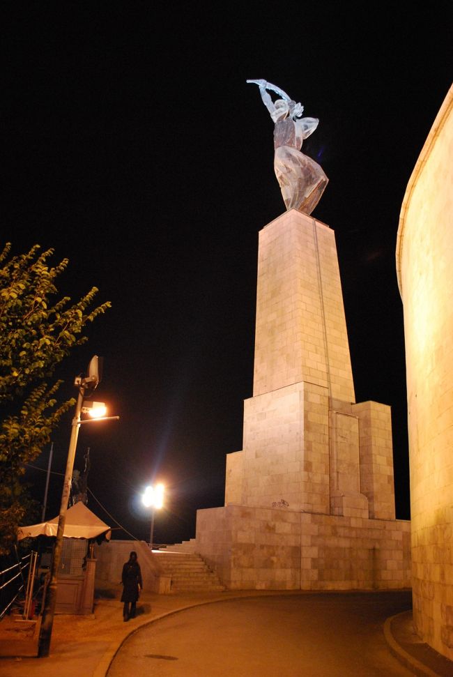 しゅろの葉を広げた女性像を後ろから。