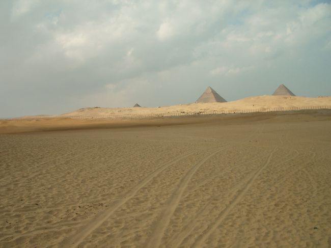 その男はアレキサンドリアで英語の先生をしており、カイロのお姉さんのところに1週間滞在して今日はピラミッドの観光に来たのだという。<br /><br />ぜったいに怪しいという気持ちもありつつ、彼のすばらしい人生論を聞かされているうちに本当にいい人なのかもという気もして来た。<br />(今思うと完全に怪しいけどね。)<br /><br />エジプト流の観光にしよう！と言われ、いつのまにか一緒に観光することになってるし。。。<br /><br />『ギザのピラミッドはつまらないから、サッカーラまで行こう！』<br />と言われ、<br />時間ないから3時間だけなら付き合うよということで合意し一緒に行くことに。<br /><br />ラクダに乗り込み(35LE/1時間)←今思えば高いよね<br />一番見たかったギザのピラミッドを背に、ぐんぐん南へ。<br /><br /><br />クフ王〜また明日来るからね〜。