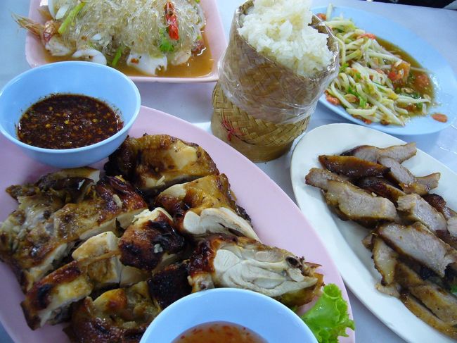 炎天下の下動き回って、お腹ぺこぺこ〜。<br />せっかくだからタイらしい食事を楽しむぞってことで、イサーン料理(タイ東北地方料理)屋さんへ。<br />ソムタム(パパイヤサラダ)、ガイヤーン(焼き鳥)、コームーヤーン(豚のノド肉焼き)、ヤムウンセン(春雨サラダ)…スパイシーな料理の数々と、シンプルなカオニャオ(もち米)がぴったり！