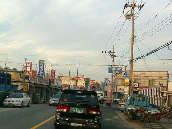江景（カンギョン）の町<br /><br /><br />夕暮れの江景（カンギョン／Ganggyeong）の中心部当たりでしょうか？<br />車で通りすぎただけですが、田舎のこぢんまりした町という感じでした。