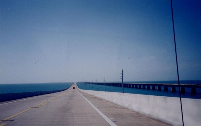 　海上を走っていた道がぐんぐん上っていって、そのまま空へ飛んでいってしまうかと思うと頂上に達し、その頂上からの眺めがすばらしい！<br />　まるでジェットコースターです。<br /><br />　「この頂上で車を停めて景色を眺めたら、やっぱりおこられるかな。」<br /><br />　それは思いとどまりましたが、きっと、ここを通った誰もが、一度はそんなことを考えるのではないかと思うのでした。<br /><br />　右手には、かつて走っていた東海岸鉄道の名残が残されていて、釣り人が点々と糸を垂れているのが見えます。<br />　この鉄道は、１９３５年にフロリダをおそったレーバーデイハリケーンで、破壊されてしまいました。<br />　その２年後には鉄道のかわりに、自動車道路がつくられたのです。<br />　時代の流れですね。